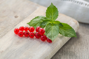 Fresh red currant on wooden background. Close up photo of the fresh berries. Harvest Concept