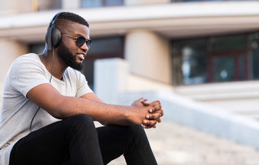 African guy in headphones listening to music having good mood