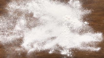 Sprinkled wheat flour on wooden table, empty space
