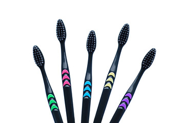 Five black toothbrushes with carbon soft bristles close-up. White isolate