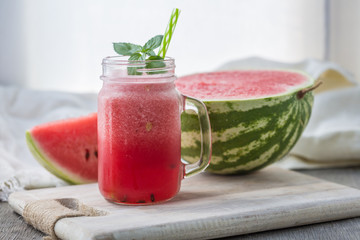 Photo of watermelon smoothie in jar with straw on light background. Fresh organic Smoothie. Health or detox diet food concept.
