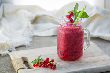 Photo of red currant smoothie in jar with straw on light background. Fresh organic Smoothie. Health or detox diet food concept.