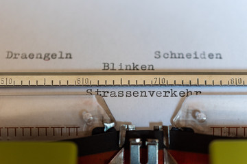 Typewriter with a leaf and the words Draengeln, Schneiden, Blinken und Strassenverkehr (Draining,...
