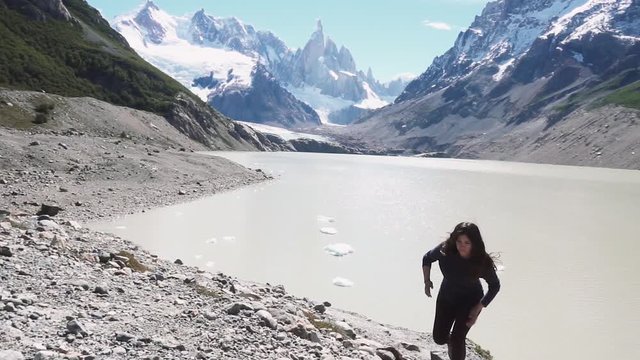 Hispanic woman trail running on the slope of the Fitz roy mountain, Calafate, Argentina. Slow motion