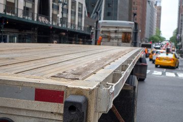 close up of a tracker trailer flat bed truck on a new york city midtown street with yellow cabs and...