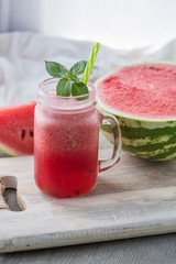 Photo of watermelon smoothie in jar with straw on light background. Fresh organic Smoothie. Health or detox diet food concept.