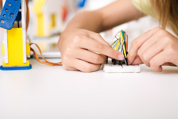 Child's hands working with wires and circuits