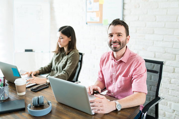 Fototapeta na wymiar Male And Female Colleagues Using Computer At Desk
