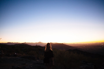 silhouette of woman on top of mountain at sunset