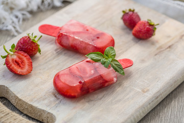 Homemade fruit popsicle stick. Delicious homemade strawberry popsicle stick on light background