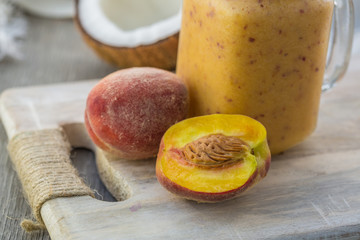 Photo of peach smoothie in jar with straw on light background. Fresh organic Smoothie. Health or detox diet food concept.
