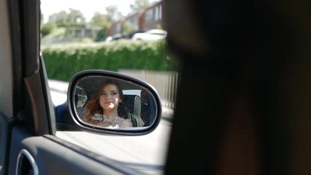 reflection in the side mirror of the car stylish and fun girl bride