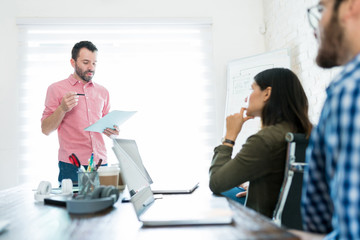 Obraz premium Professional Explaining Project To Colleagues In Office