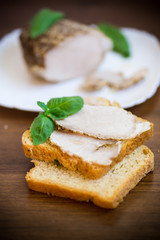 sandwich with home baked meat in a plate on a wooden