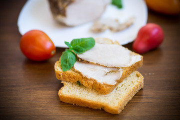 sandwich with home baked meat in a plate on a wooden
