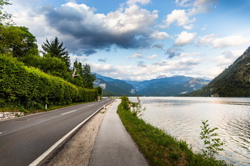 Road along the mountain lake. Summer evening. Austrian Alps.