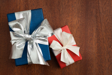 Two  gift boxes with ribbons on wooden background