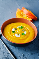 Pumpkin soup with pumpkin seeds and parsley leaves