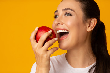 Girl With Perfect White Smile Holding Apple On Yellow Background