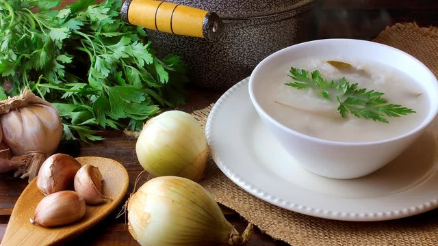 congee in ceramic bowl on rustic wooden table, traditional rice porridge typical of Asian cuisine