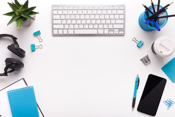 Office table with plants, keyboard, cellphone with blank screen