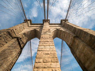 Wide Angle View of the top one of Brooklyn Bridge Brick Towers With Mostly Clear Skies