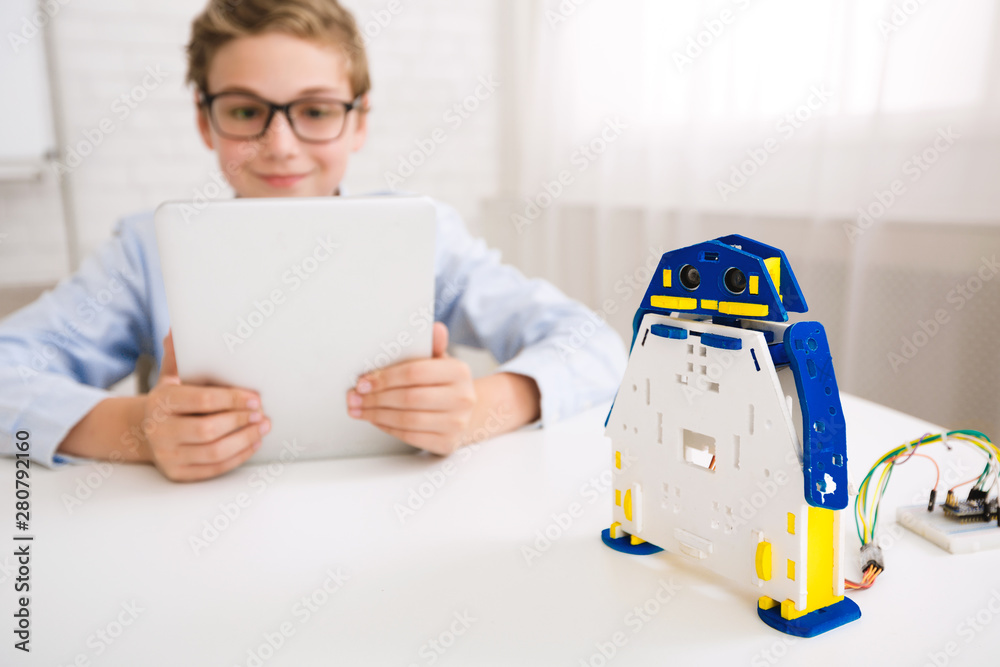 Poster Boy programming robot with tablet computer in class