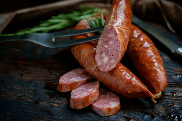 Fototapeta Bavarian smoked sausages from pork cut on a wooden Board. Rustic style obraz