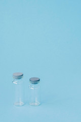 Vial of medicine on blue background with copy space. Antibiotic or vaccine medication. Healthcare and pharmacy innovations