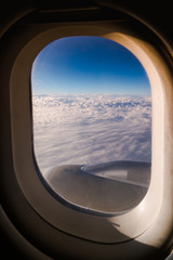 Fototapeta na wymiar A beautiful view of white fluffy clouds from the window of an airplane. Perfect for a travel concept.