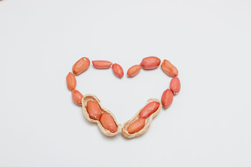Peanuts, for background or textures. Uncleaned inshell peanuts. Peanuts isolated on white background. Valentine's Day, Flat lay. Copy space.