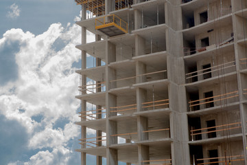 Modern building under construction detail, concrete frame, indow openings and scaffolding