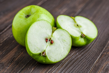 Ripe green apples and apple slices on old wooden background.Vegan and vegetarian concept.Concept for healthy eating and nutrition