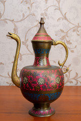 Metal jug with a cover and east ornament