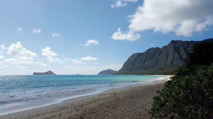 Two Fishing Poles in the sand as Gentle wave lap on Waimanalo Beach