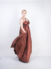 young pregnant girl in a long brown pleated evening dress