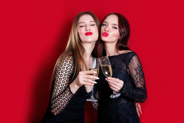 Pretty brunette girl friends having fun drinking cocktails. Singing and dancing on party.