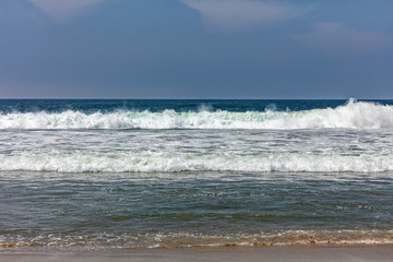 Sandy beach empty. Blue sky, blue sea with waves