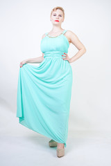 curvy plus size woman in long mint blue dress on white isolated studio background standing