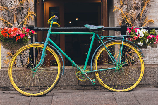 Multicolored vintage bike. Two-wheeled transport stoin on the background of the house with open doors.