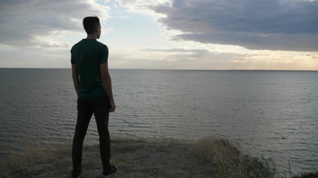 Sportive young man standing and enjoying the view of the Black Sea in slo-mo 
