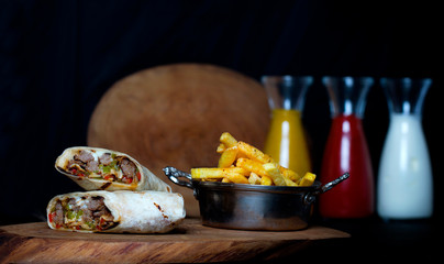 Traditional Turkish doner kebab rolled in thin lavash bread with cheese,tomatoes,red and green...