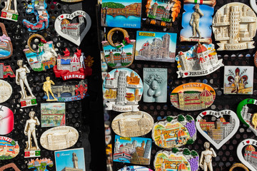 View of traditional tourist souvenirs and gifts from Florence, Tuscany, Italy with toys,  fridge magnets with text "Florence" in local vendor souvenir shop