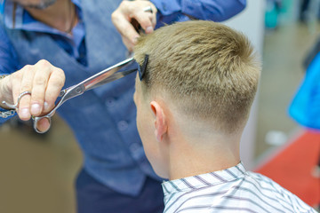 Barber man at work. The man is cutting his hair. Barbershop. Hair cutting scissors. Working day at the hairdresser.