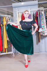 Naklejka premium pretty plus size short hair girl in shopping process in the big pin up clothes store