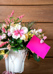 flower and blank pink note paper on it. with wood background
