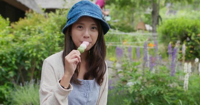 Woman enjoy dango in japanese garden