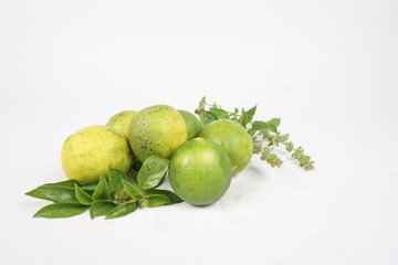 green lemon with leaves on white background