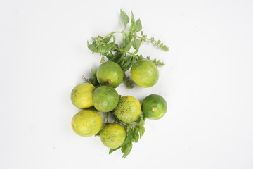 green lemon with leaves on white background