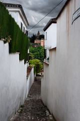 white wall and narrow street in albaicin, granada, view of a narrow street in albaici, the arab quarter in granada. spain